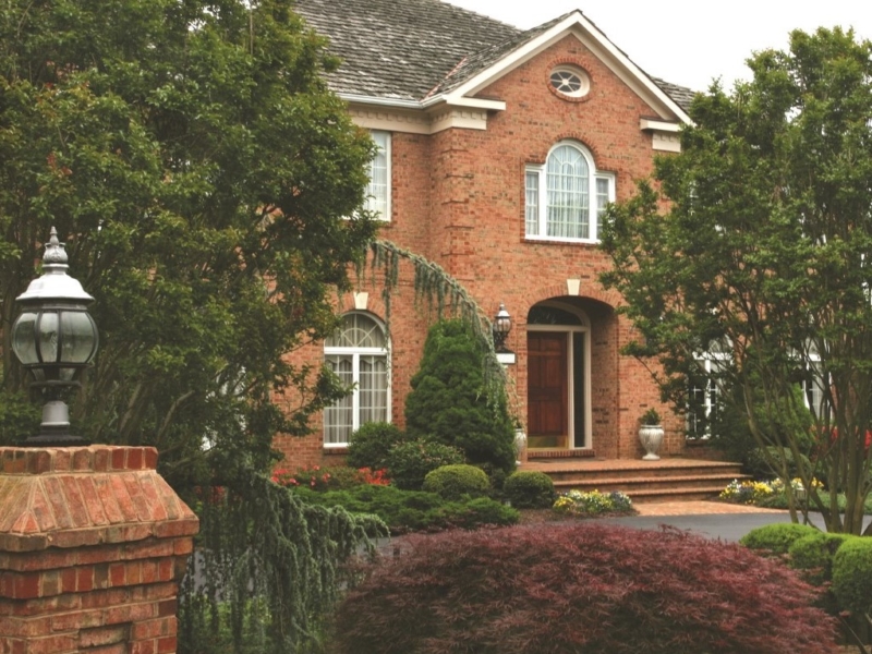 Evergreen plantings in front of brick home